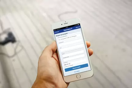 En Iphone som hålls i handen med Garantera